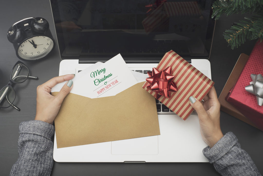 business woman hand holding christmas card and gift box on desk office concept office christmas and happy new year.